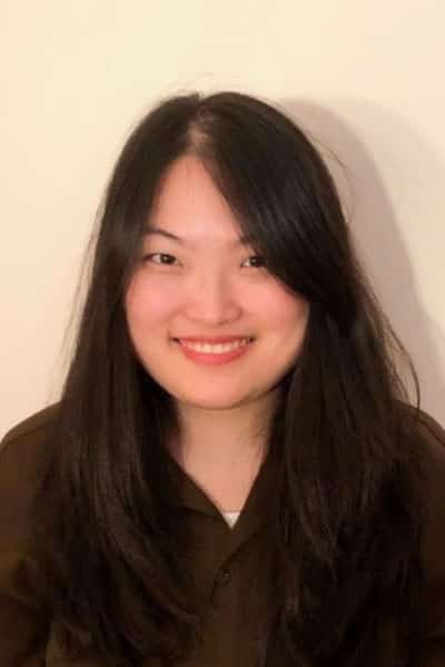 A headshot of Annie. She has long black hair and is smiling.