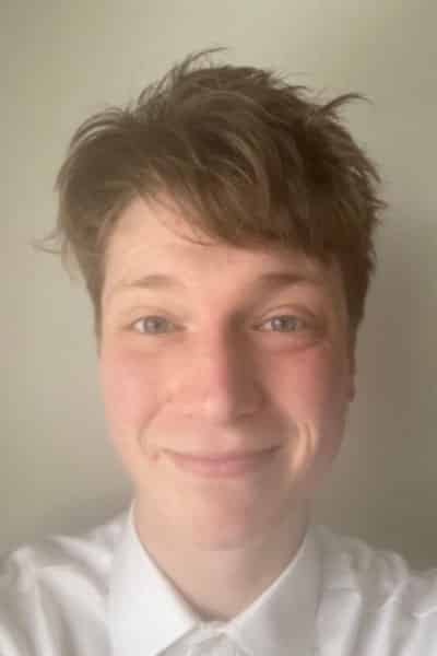 A headshot of Hamish. He has short hair and is smiling.