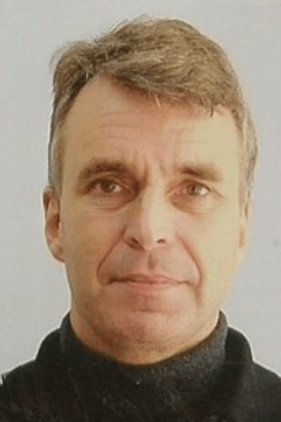 A headshot of Michael. He has short hair and is wearing a turtleneck.