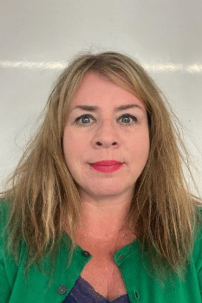 A photo of Rachael. She is wearing a green top and is smiling.